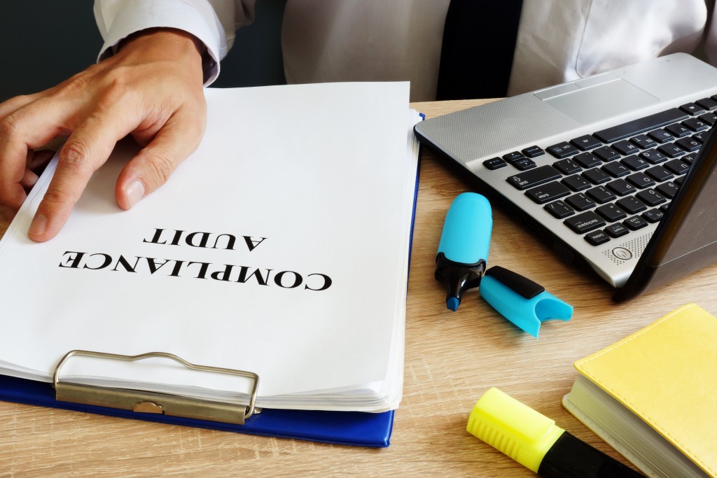 man holding documents for the compliance audit