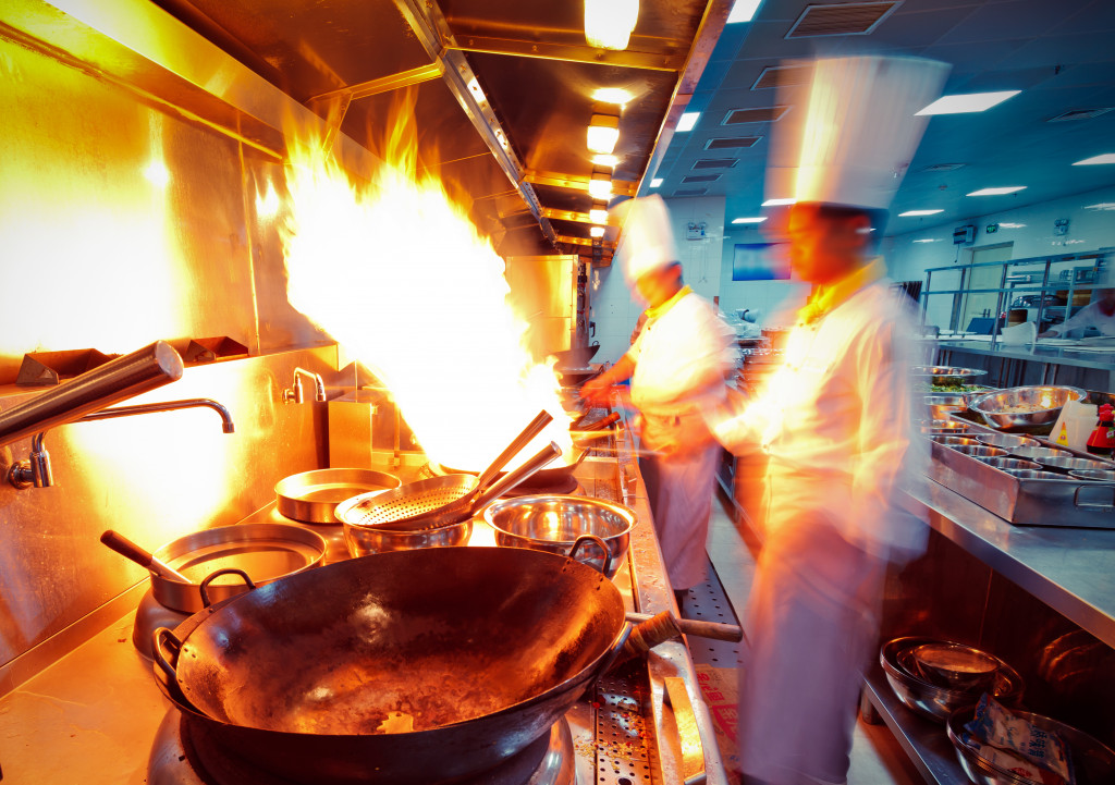 A cooking space with woks and chefs