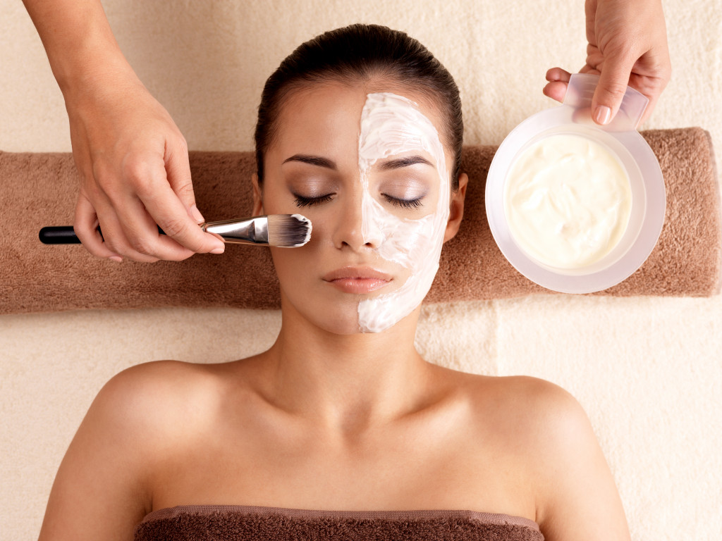 A young woman getting her facial done from a professional