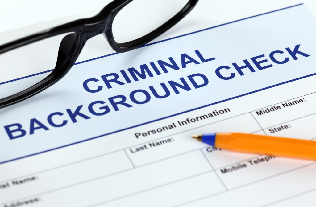 A criminal background check application and a pen and glasses