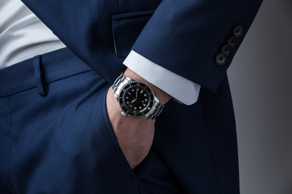 A businessman in business wear with a silver wrist watch