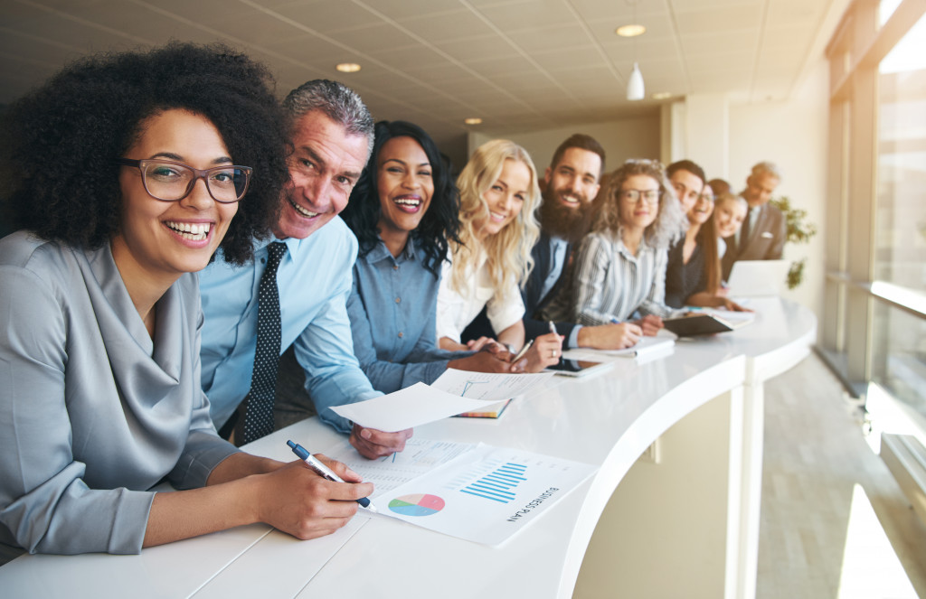 employees seated at long table smiling