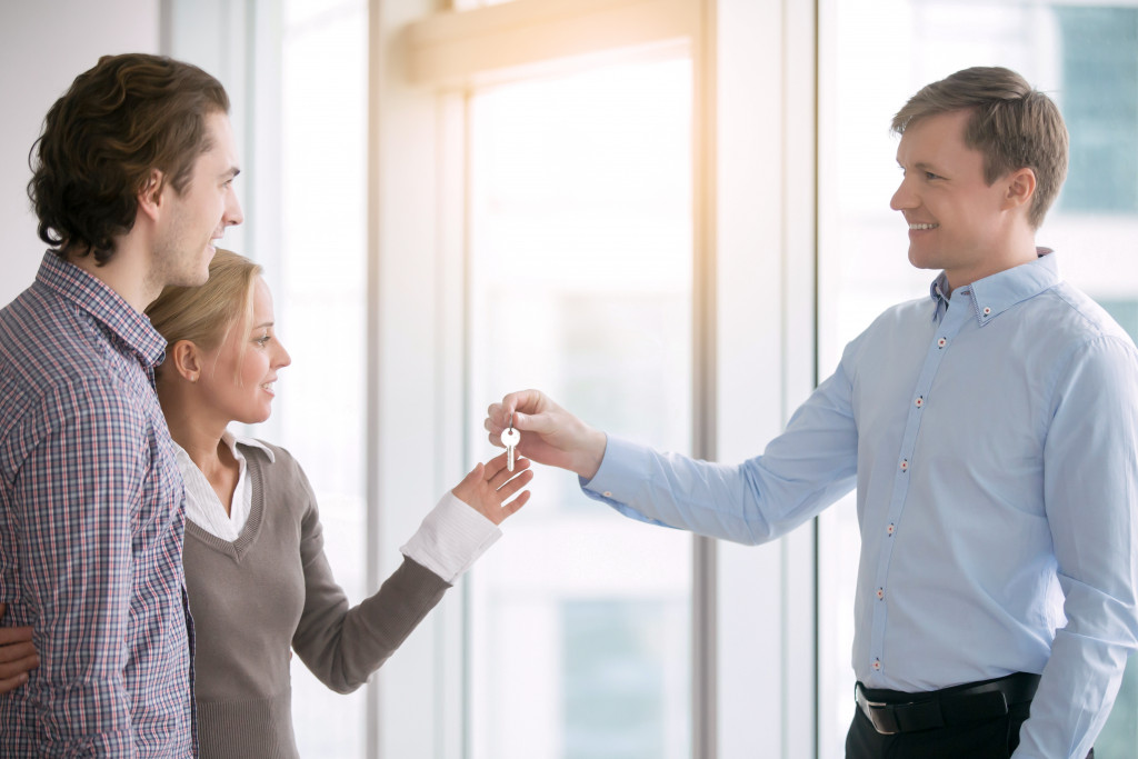 An image of a man handing keys to tenants