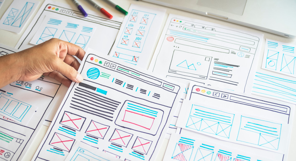 website development plans drawn on sheets of paper in a white table