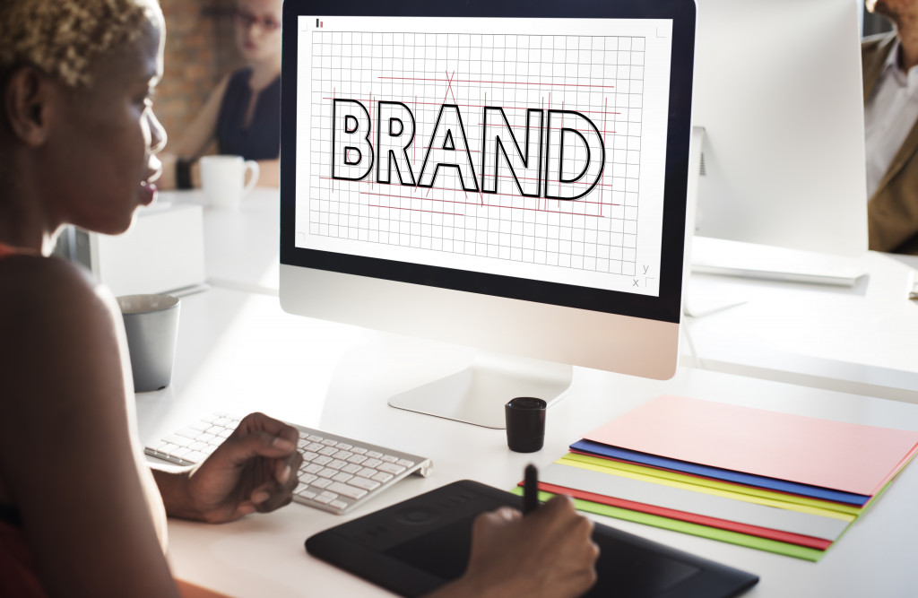 female artist sketching a brand logo digitally in her computer at office