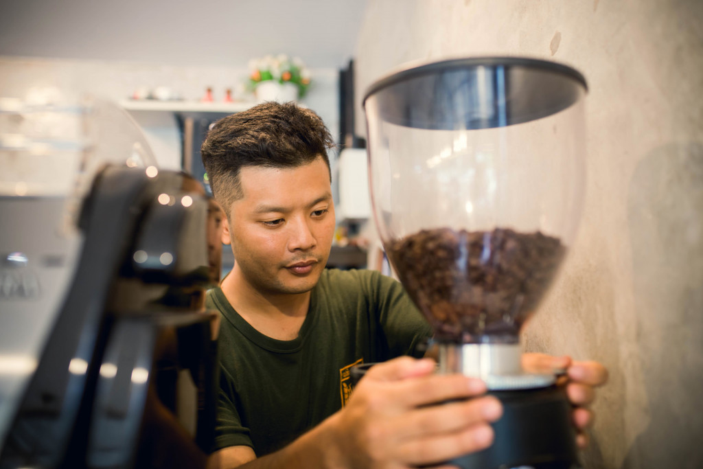 A café owner operating a coffee machine