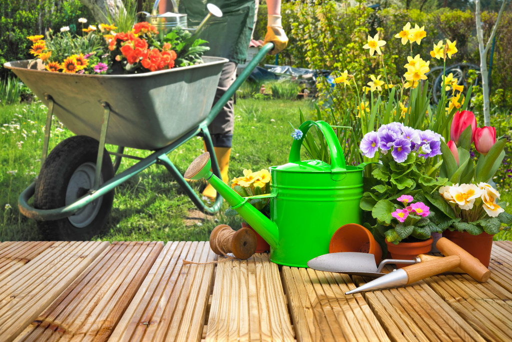 assorted simple gardening tools laid out in the wooden desk or seat in the garden