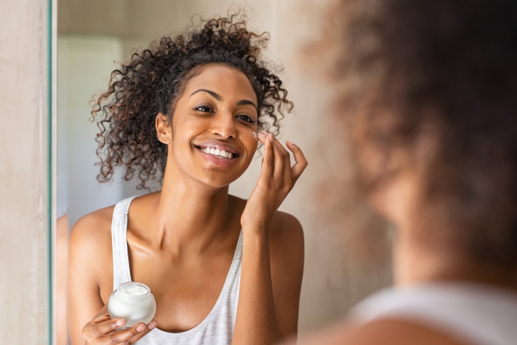 woman applying moisturizer on her face