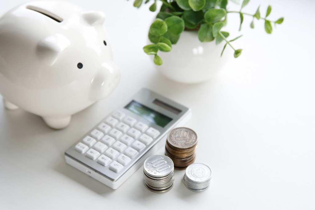 A piggy bank, a calculator, and some coins